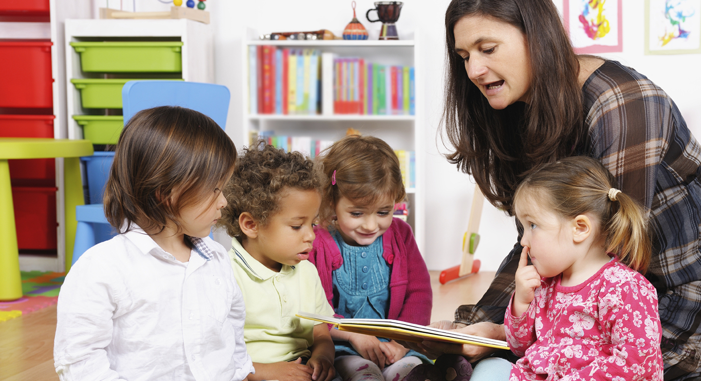 Barnehagelærer har lesestund for fire barn